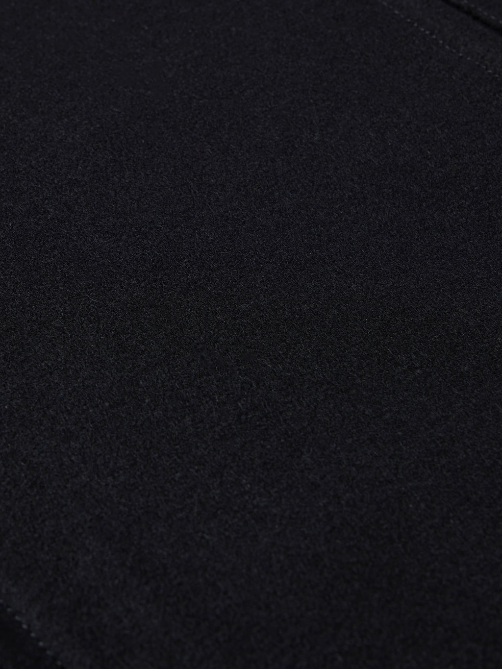 Black wool arena jacket fabric close-up with smooth knit texture