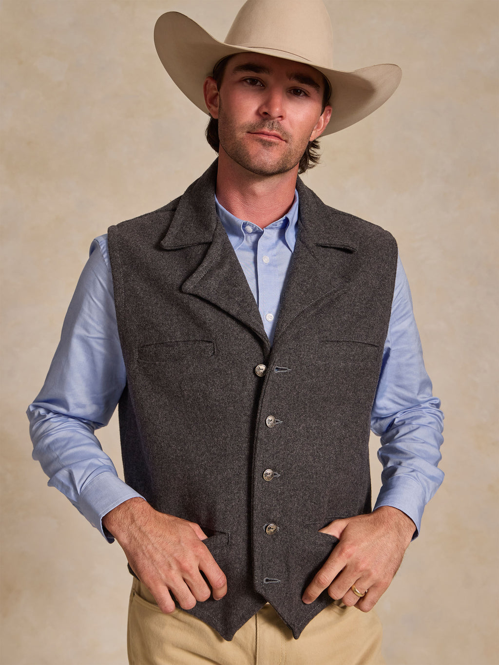 Light blue button-down collar and button placket under a dark vest