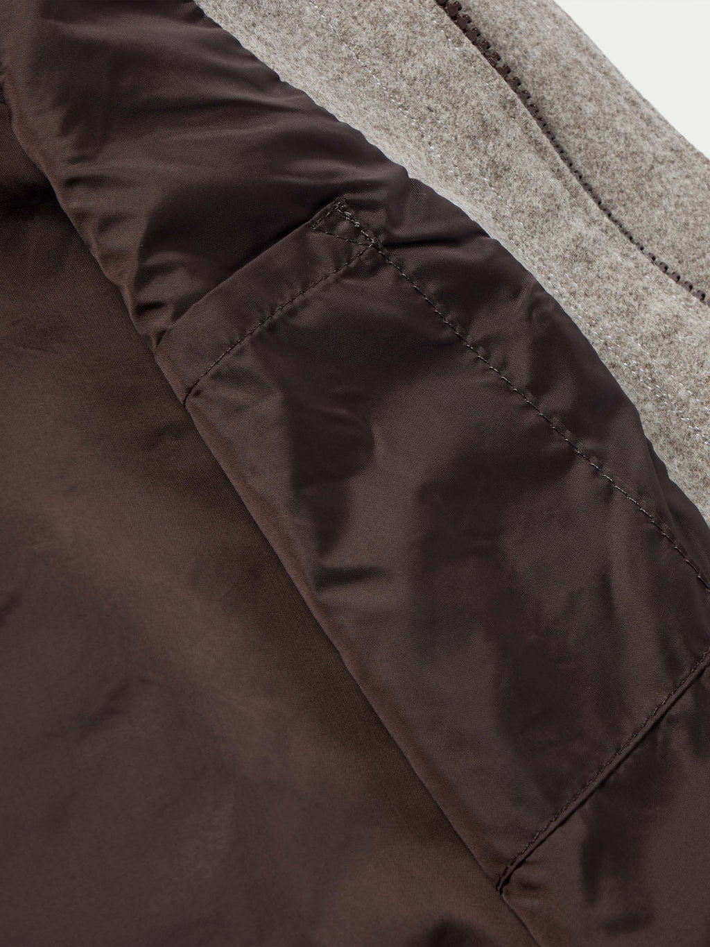 Taupe wool vest hem lining with dark fabric panel and visible stitching detail