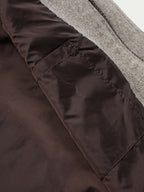 Taupe wool vest hem lining with dark fabric panel and visible stitching detail