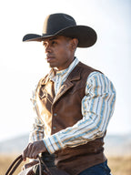 Brown leather cowboy vest with button-front and notched collar, worn over shirt