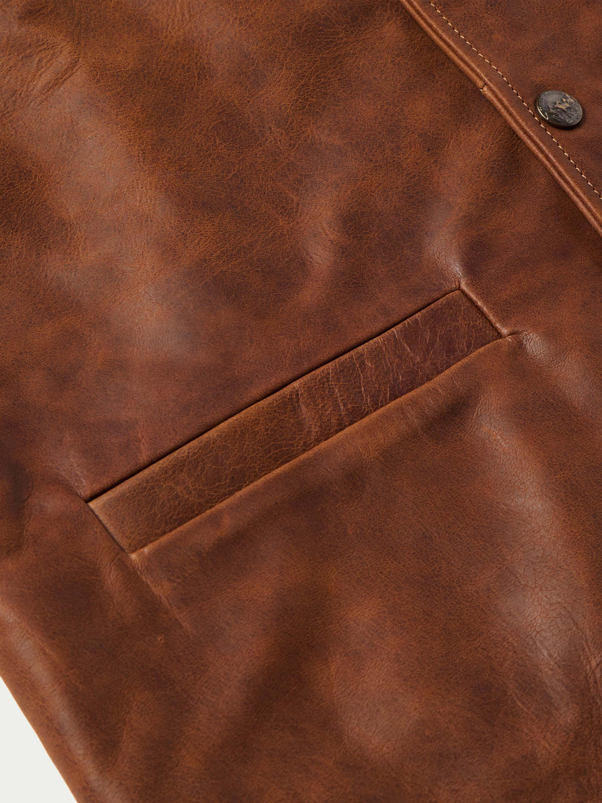 Brown leather vest panel close-up with diagonal yoke seam