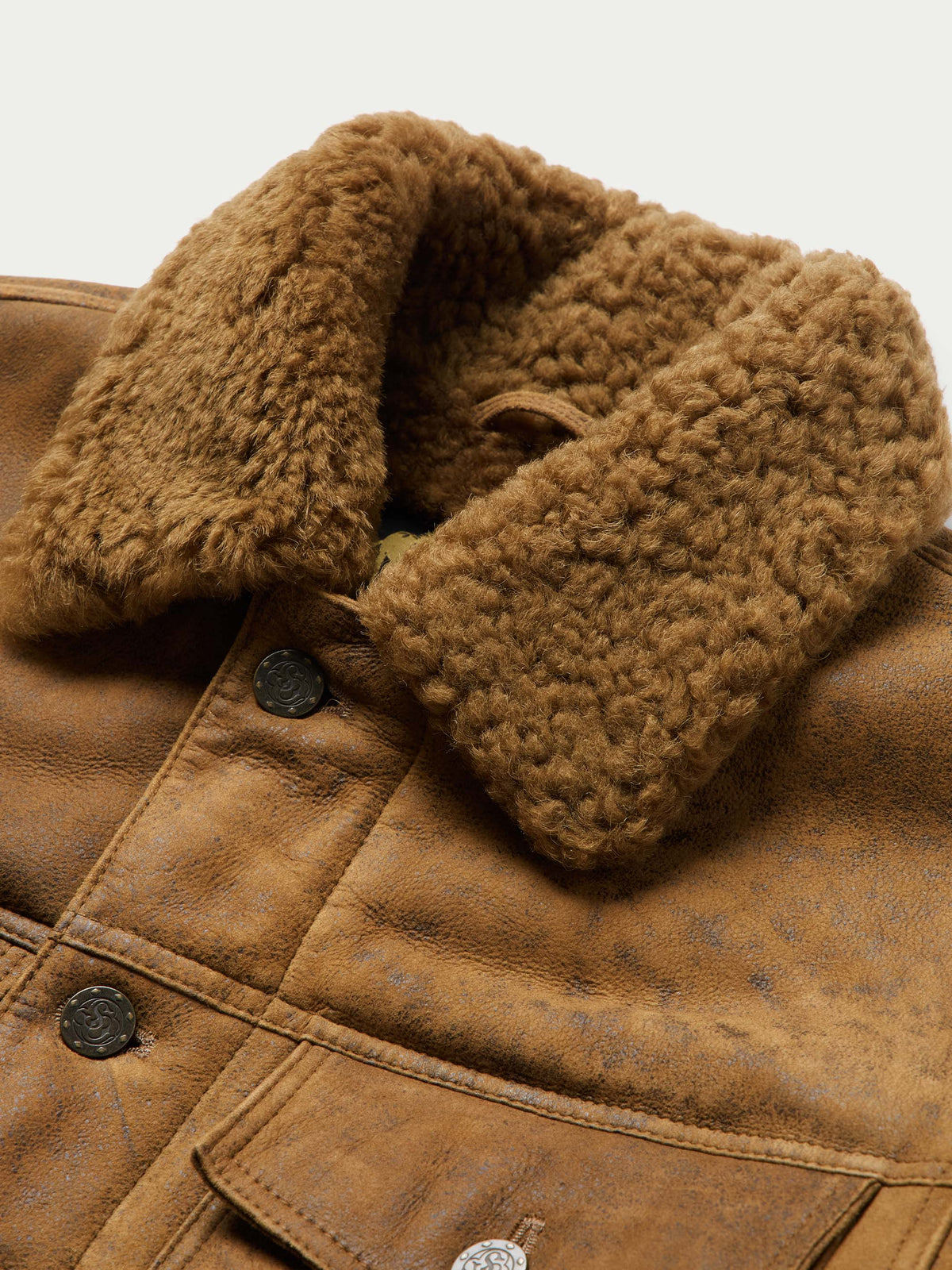 Brown trucker jacket close-up of sherpa-lined collar and snap buttons