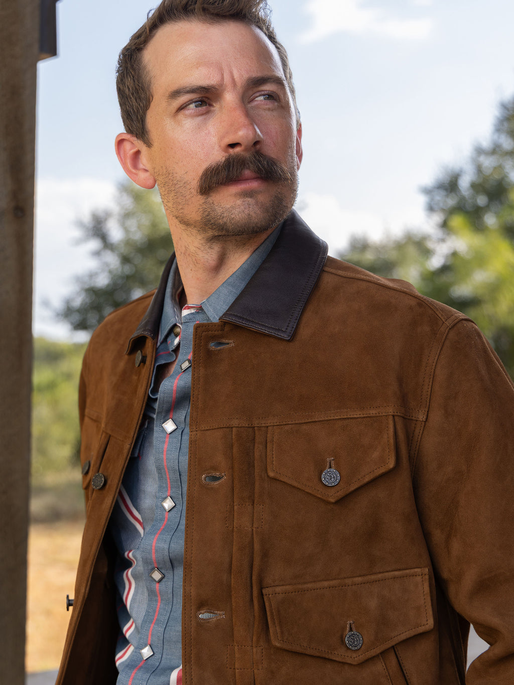 Brown suede trucker jacket with pocket flaps, snap buttons, and dark stand collar