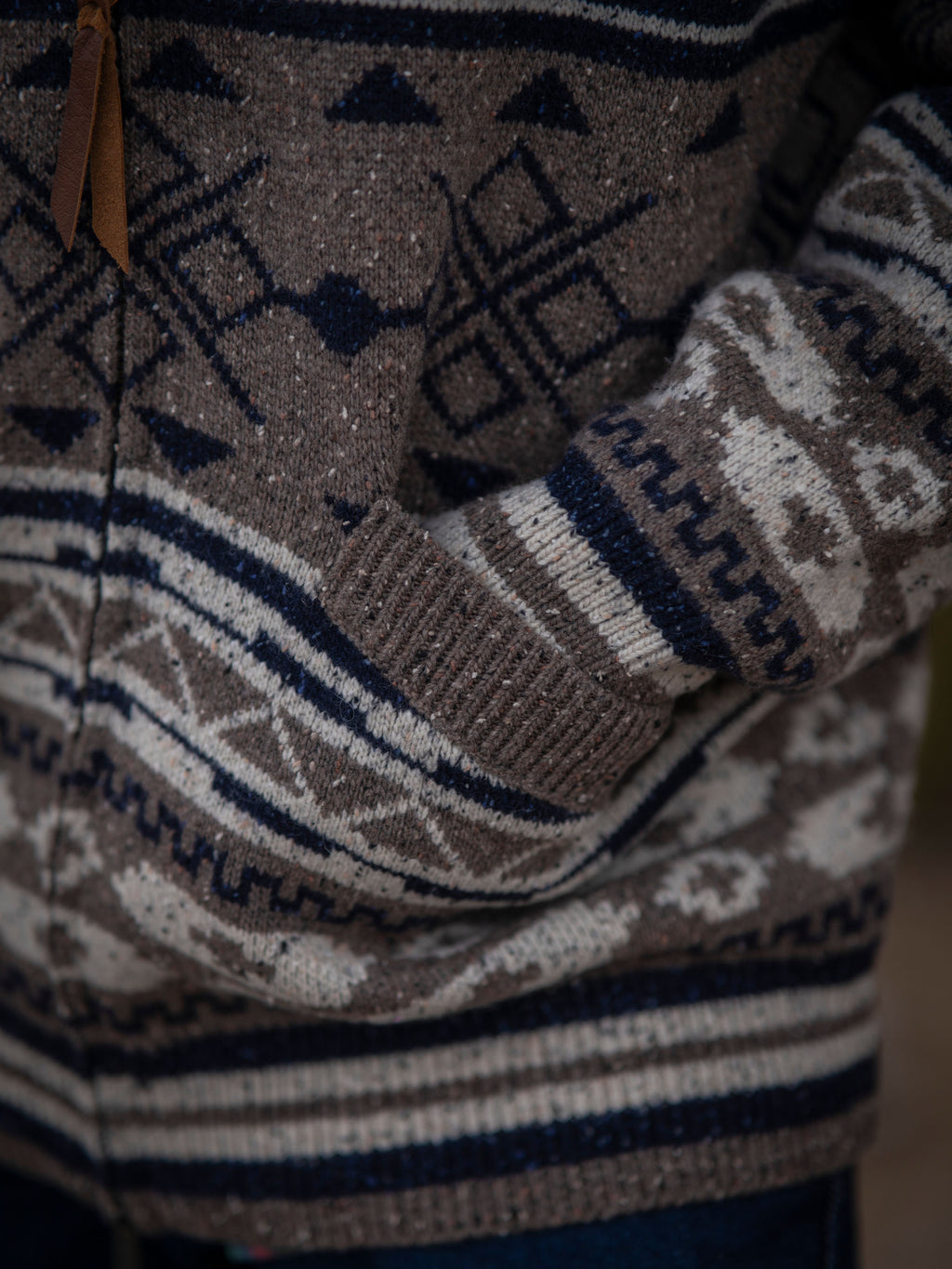 Brown knit sleeve with navy and cream stripe pattern and geometric motifs.