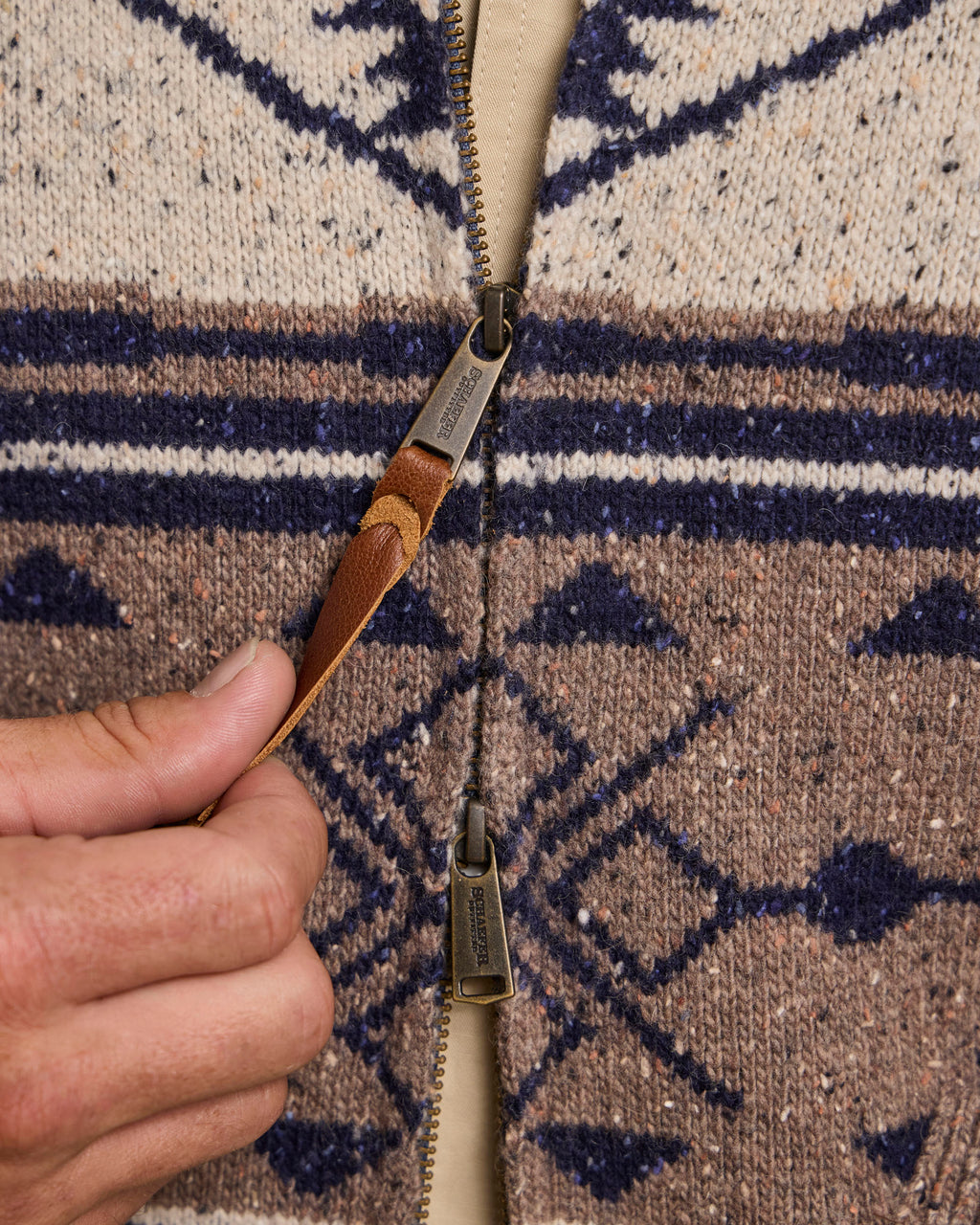 Full zip sweater zipper detail on cream, navy, and tan western knit
