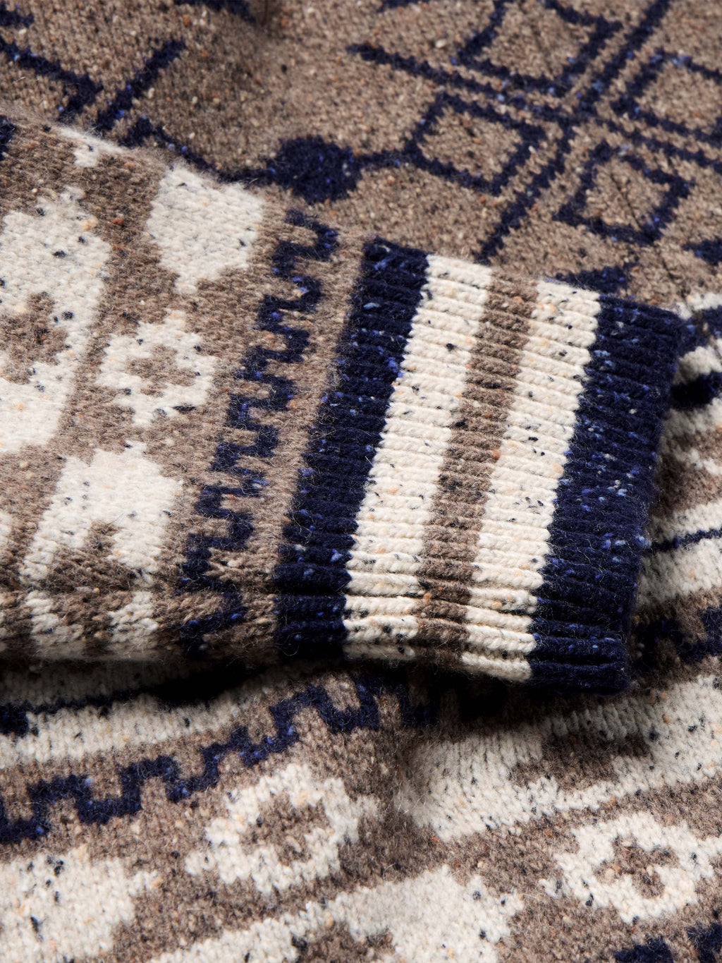 Nordic knit cuff with striped and geometric bands in navy, cream, and brown.