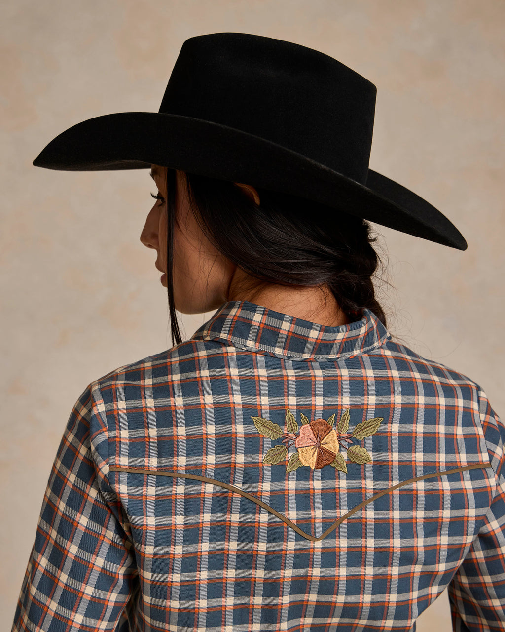Back of embroidered blue-and-orange plaid snap shirt with floral yoke detail
