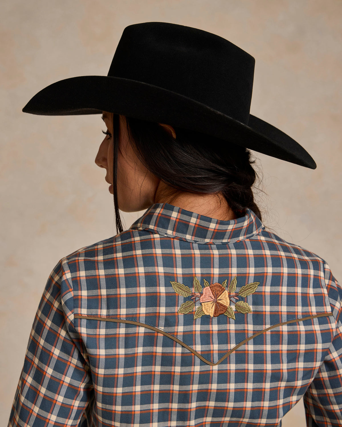 Back of embroidered blue-and-orange plaid snap shirt with floral yoke detail