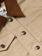 Beige jacket close-up showing chest pocket flaps and metal snap buttons
