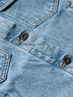 Light wash denim jacket close-up with decorative stitching and dark buttons