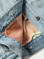 Denim jacket detail with brown flannel lining and snap buttons