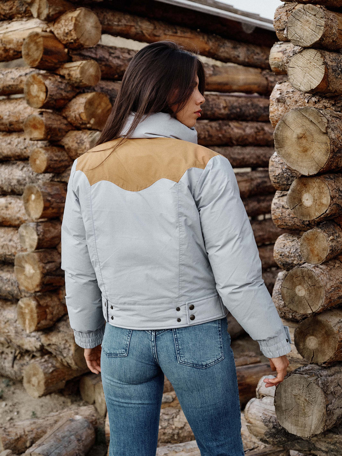 Women’s down jacket back view in light blue with tan yoke and snap-button placket