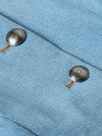Light wash denim jacket close-up with metal snap buttons and concho detailing