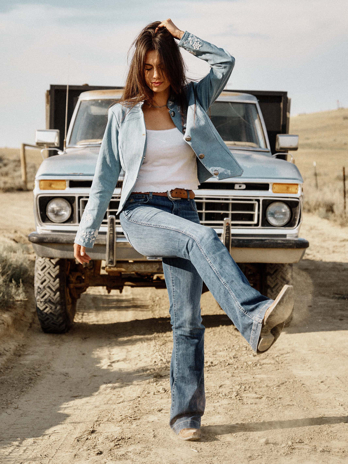 Light wash denim jacket with embroidered floral cuffs and button front, cropped fit