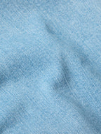 Light wash denim fabric close-up showing textured weave