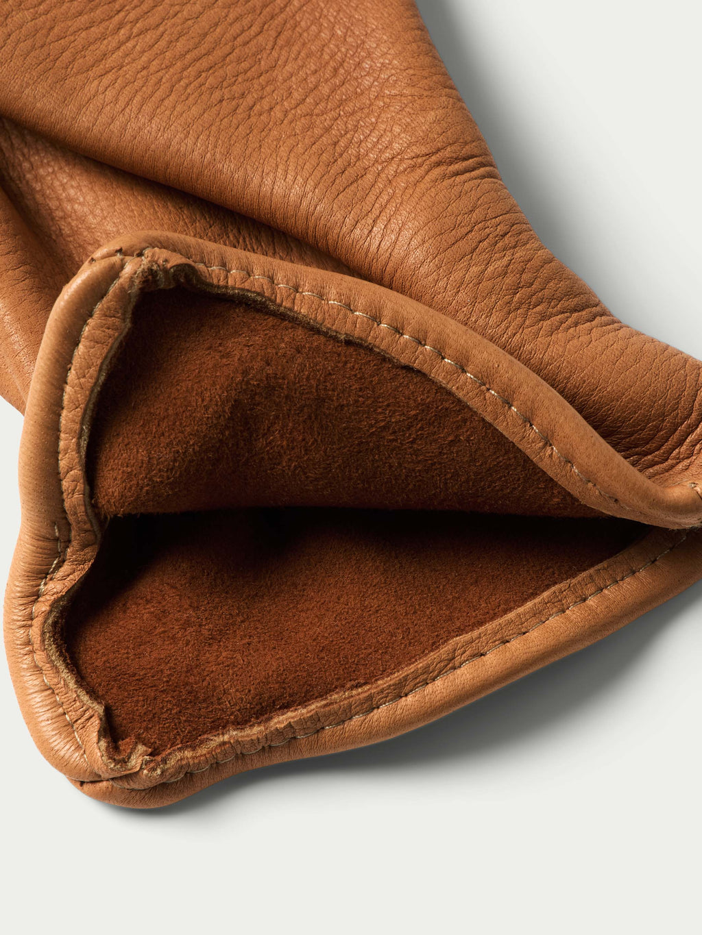Deerskin glove cuff closeup with brown lining and contrast stitching