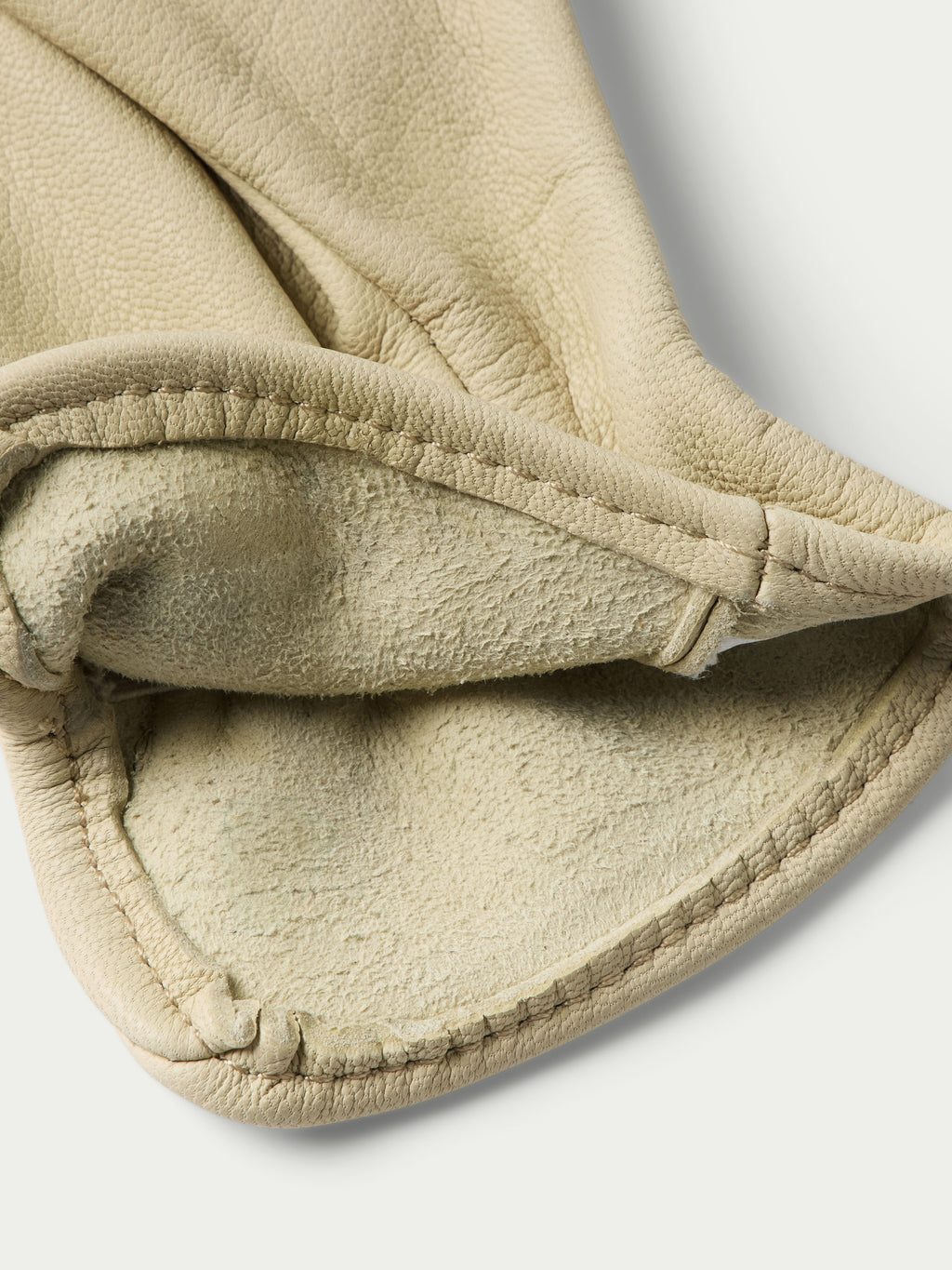 Natural goatskin glove cuff close-up with stitched band and soft lining