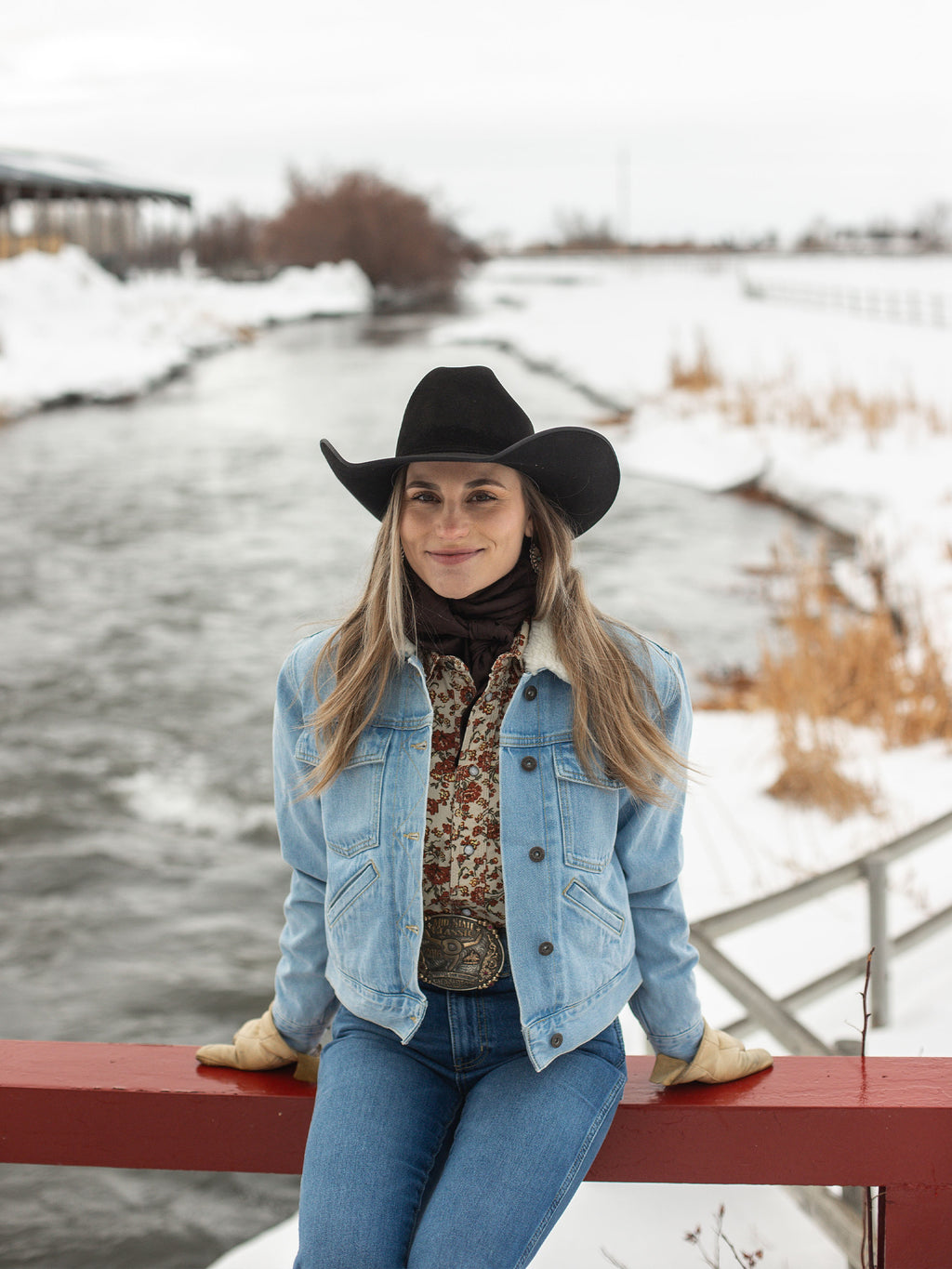 Women’s sherpa-lined light wash denim jacket worn with a dark hat