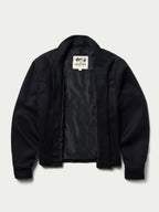 Women's black wool arena jacket with inner plaid lining visible at the zipper