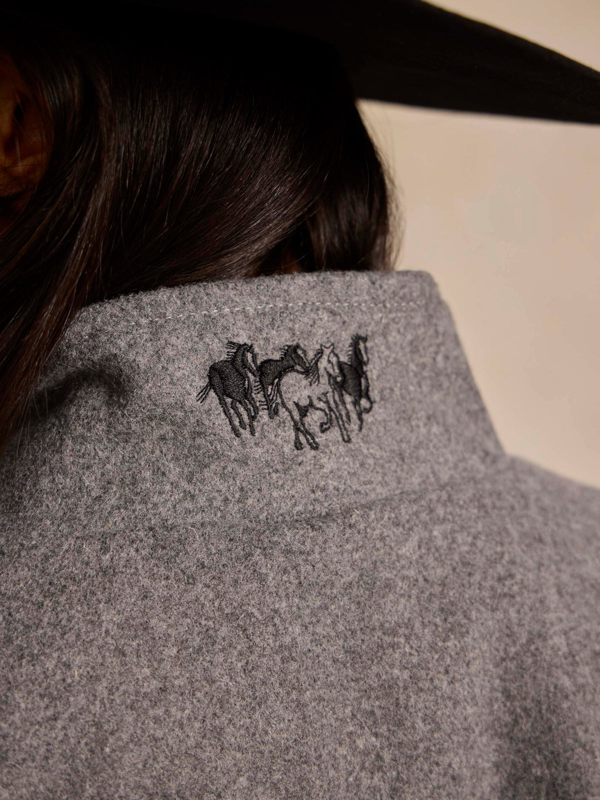 Heather gray wool jacket back panel with embroidered horse rider graphic