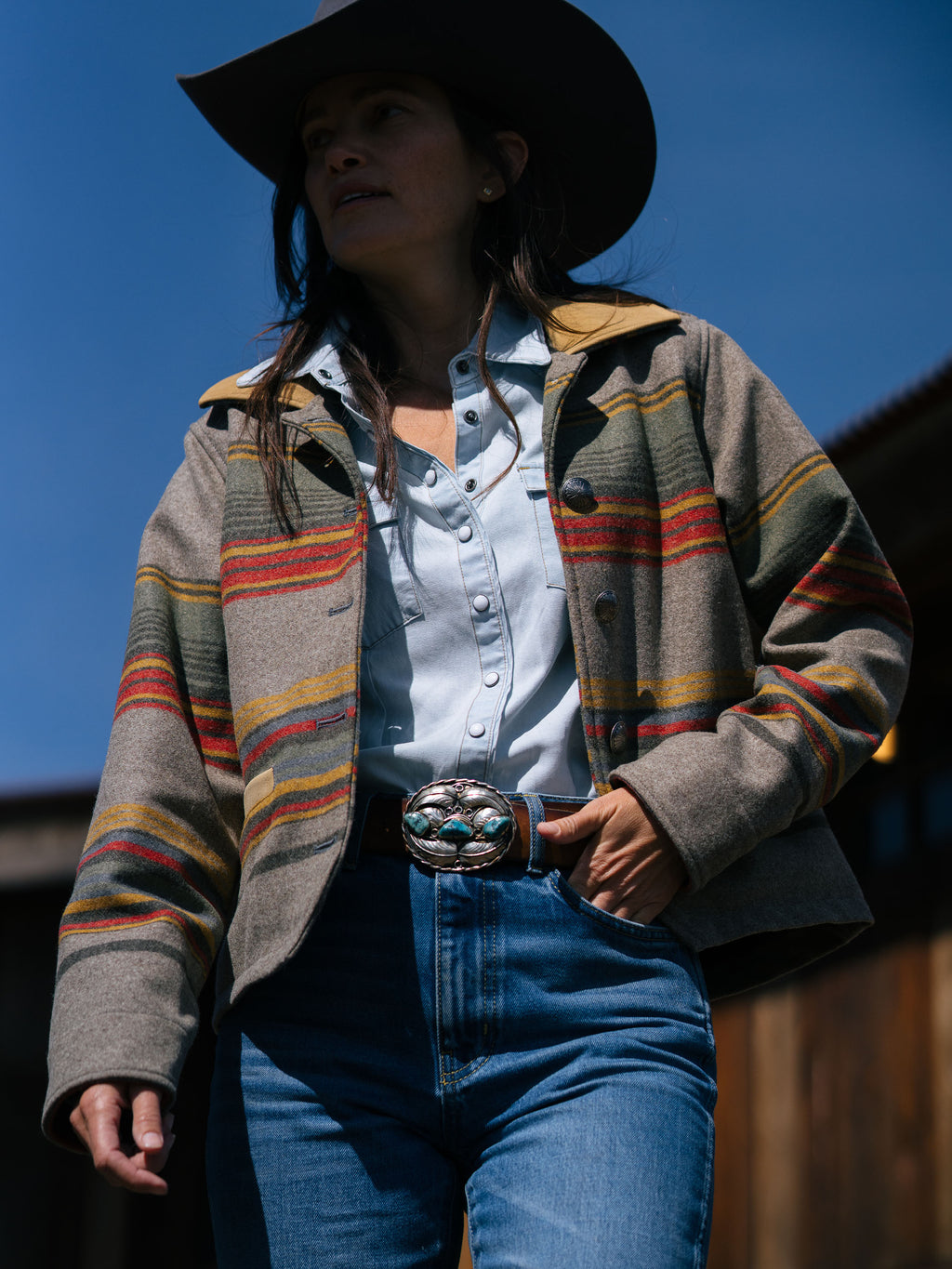 Women’s striped jacket with tan leather-look collar and chest snaps, layered over blue jeans
