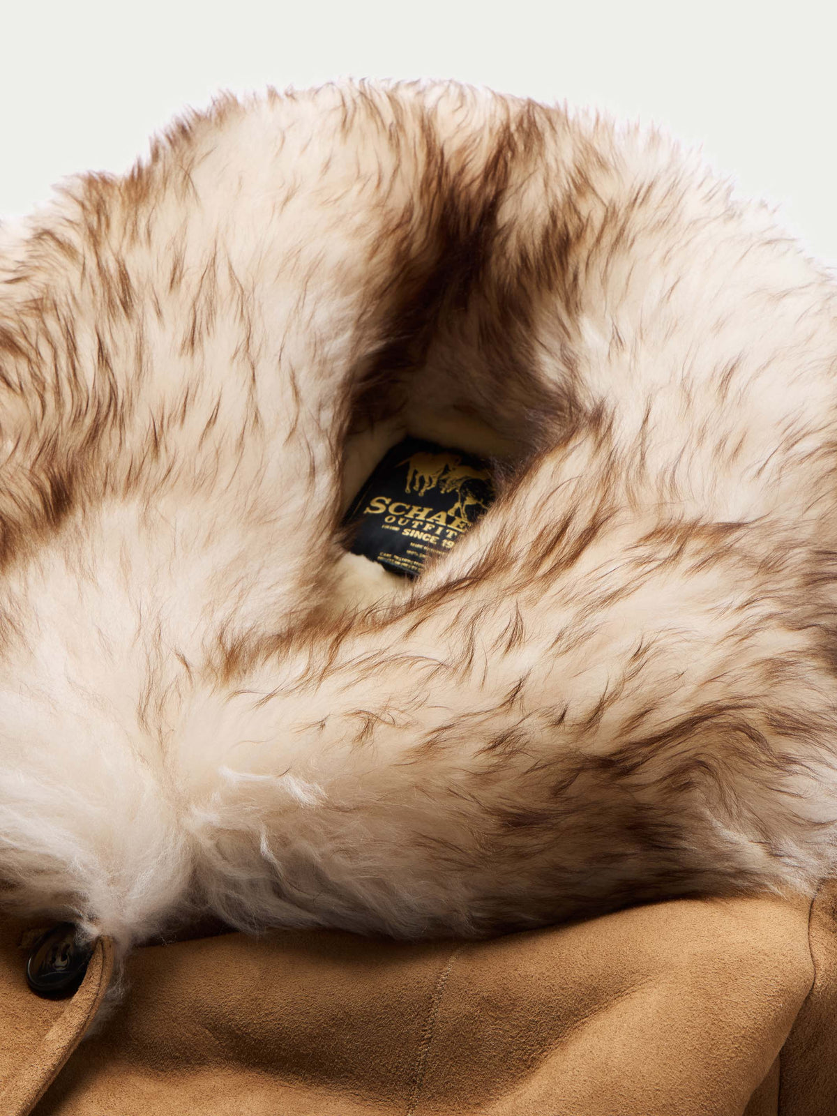 Chestnut shearling coat close-up with plush inner lining and black brand label
