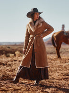 Long chestnut shearling coat with tan fur collar, tie belt, and front button placket