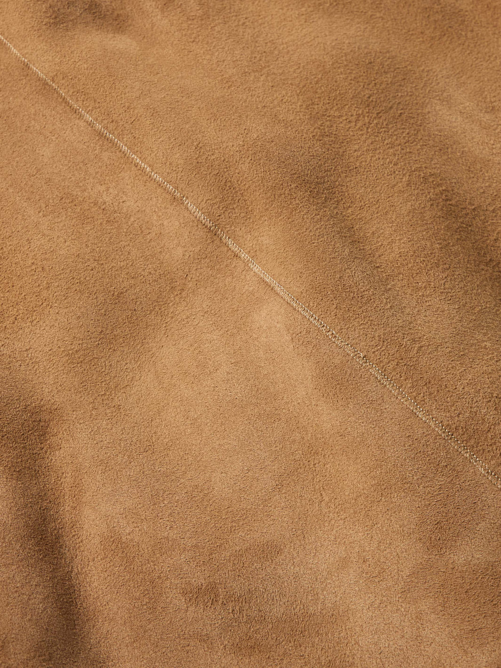 Chestnut suede shearling coat fabric with fine stitching seam detail