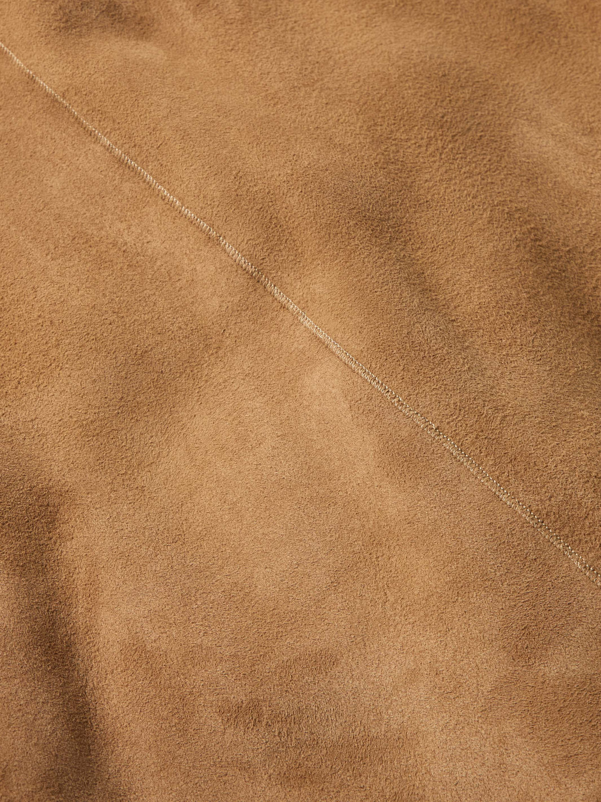 Chestnut suede shearling coat fabric with fine stitching seam detail