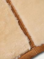 Close-up of shearling trim and seam on brown jacket edge