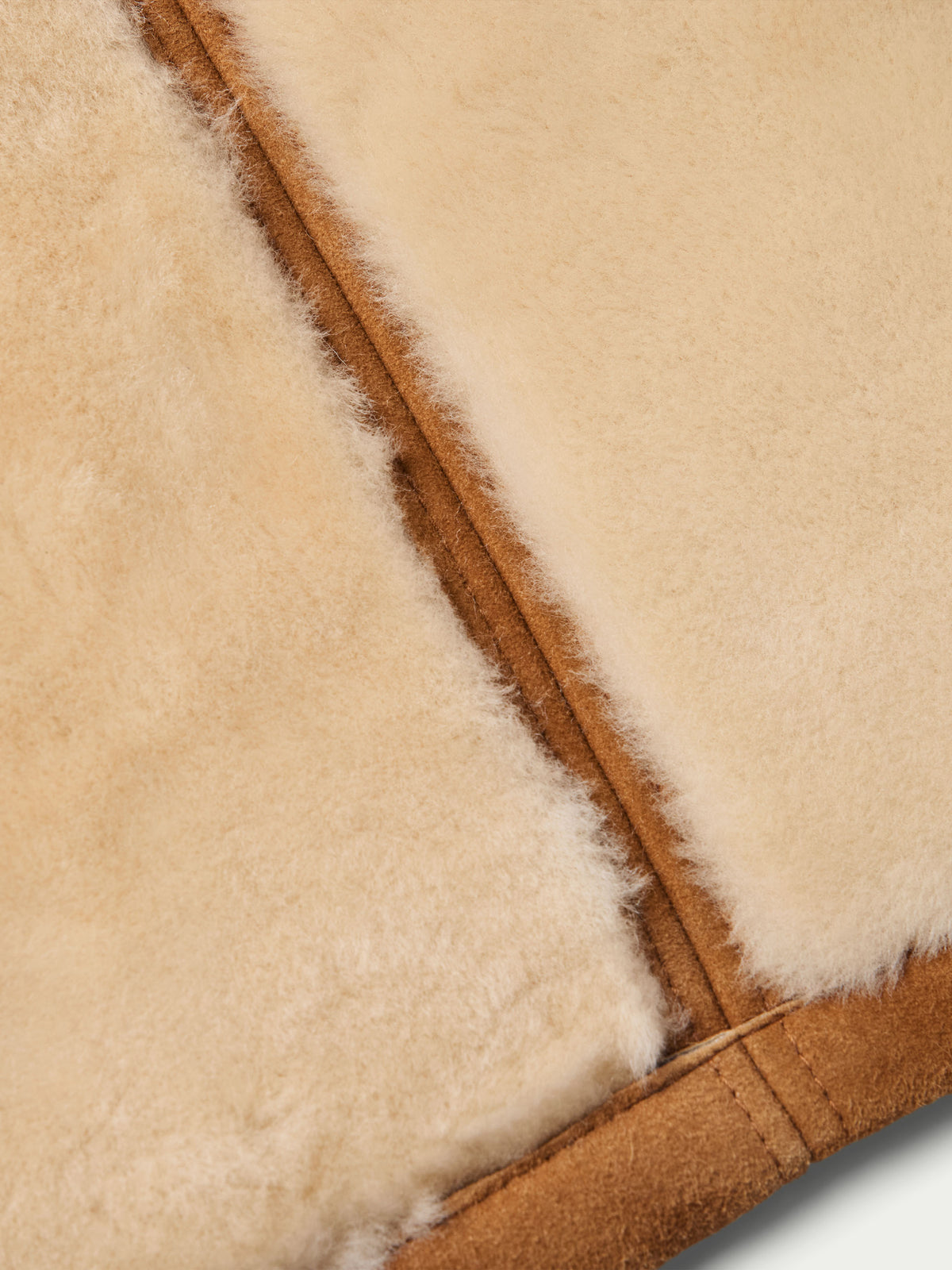 Close-up of shearling trim and seam on brown jacket edge