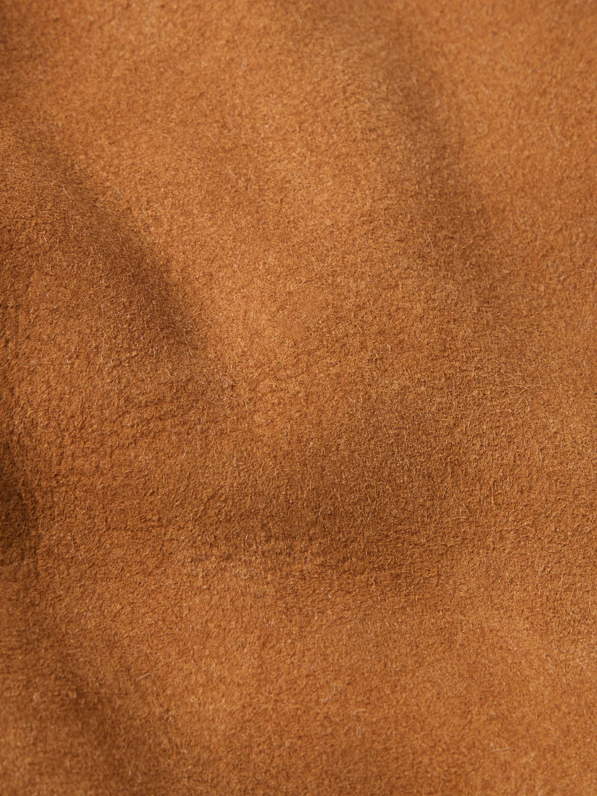 Brown suede texture close-up showing fine grain on jacket surface
