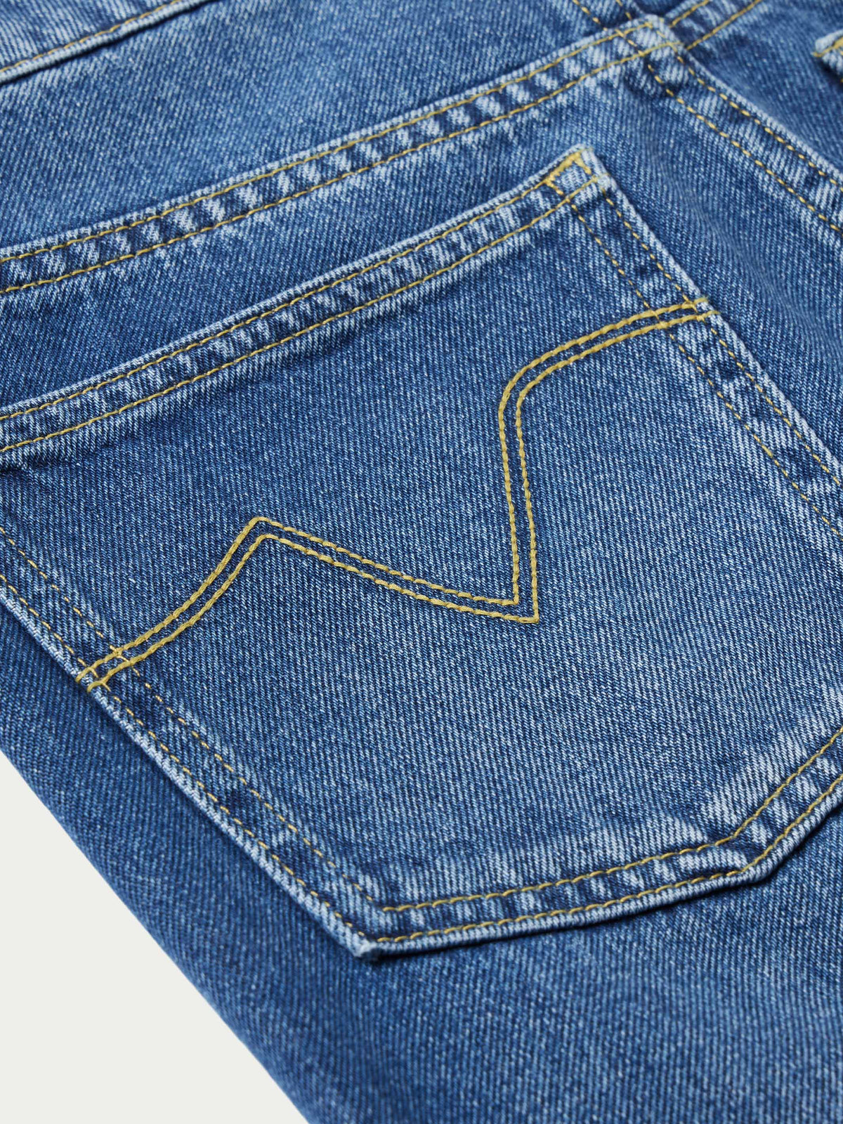 Medium indigo jeans with contrast yellow outlined pocket design