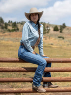 Medium indigo jeans worn by a seated person, straight-leg denim
