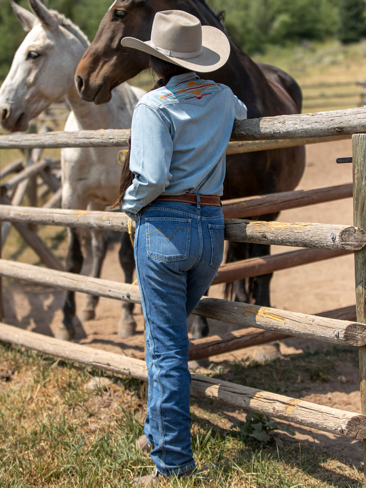 Medium indigo jeans worn by a person, front pockets and stitched seams visible