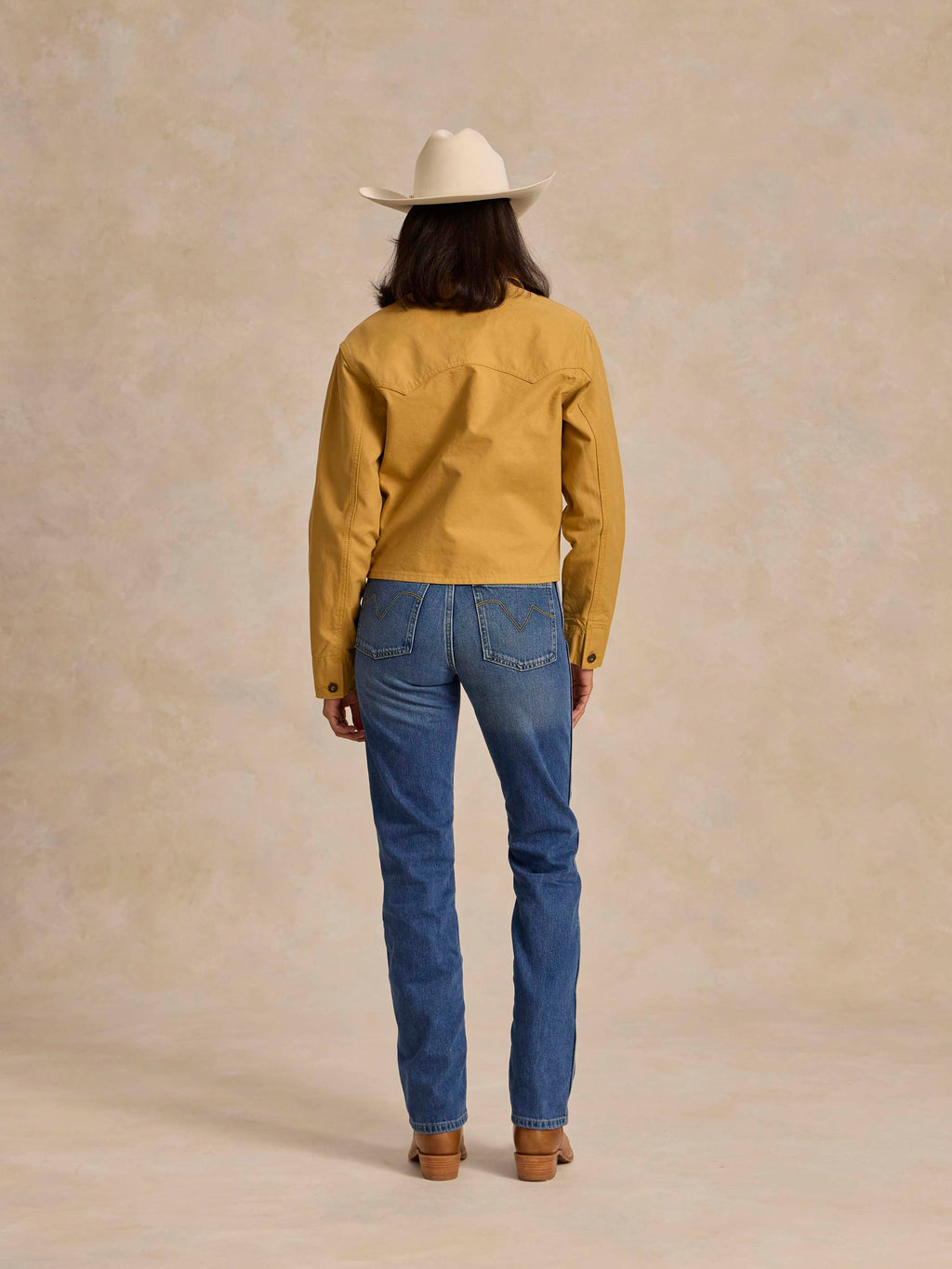Medium indigo denim jeans, back view with belt loops, patch pockets, straight leg