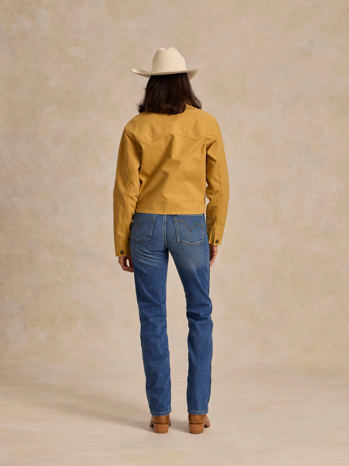 Medium indigo denim jeans, back view with belt loops, patch pockets, straight leg