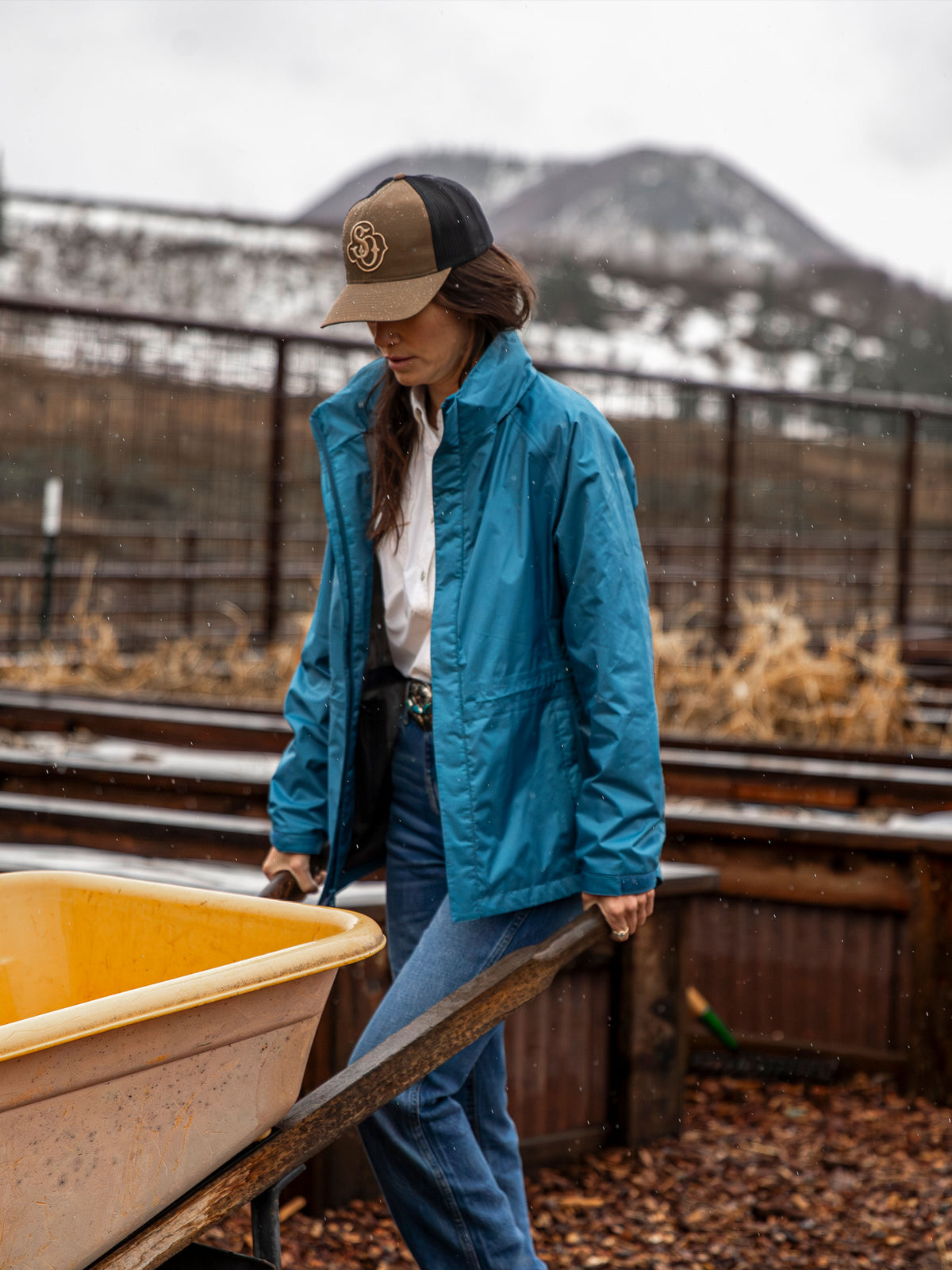 Blue hooded rain jacket with front zipper and side pockets