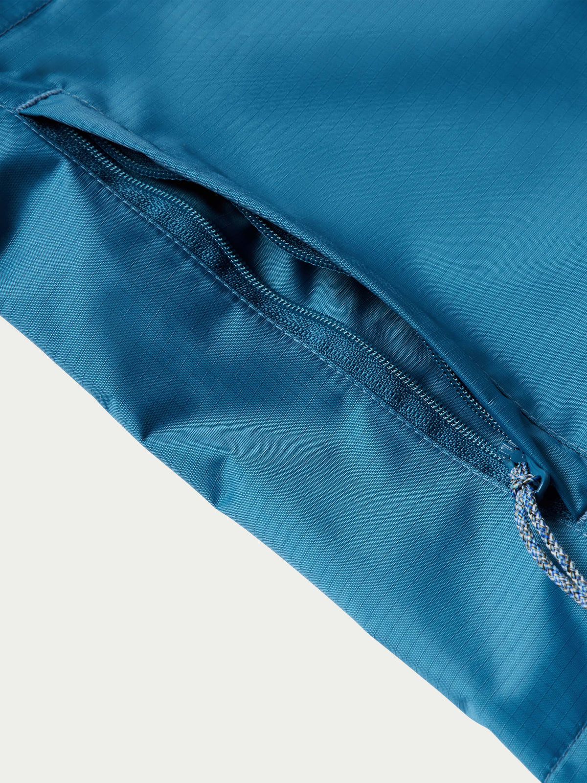 Baltic blue rain jacket sleeve hem with elastic cuff and zipper seam detail