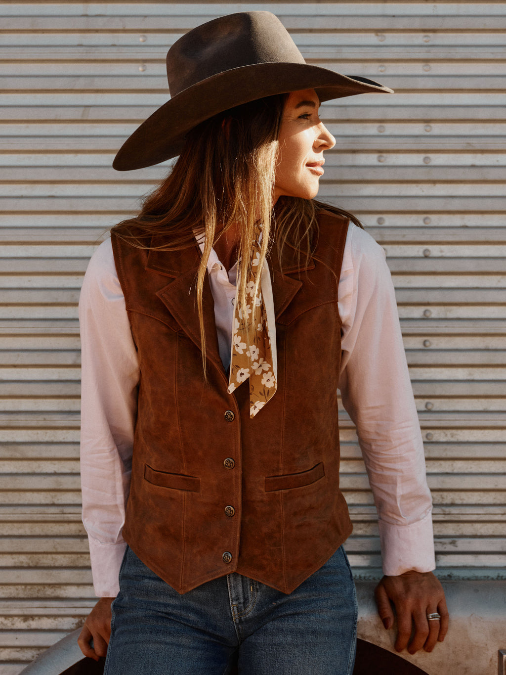 Women's whiskey-brown leather vest with flap pockets and buttoned front