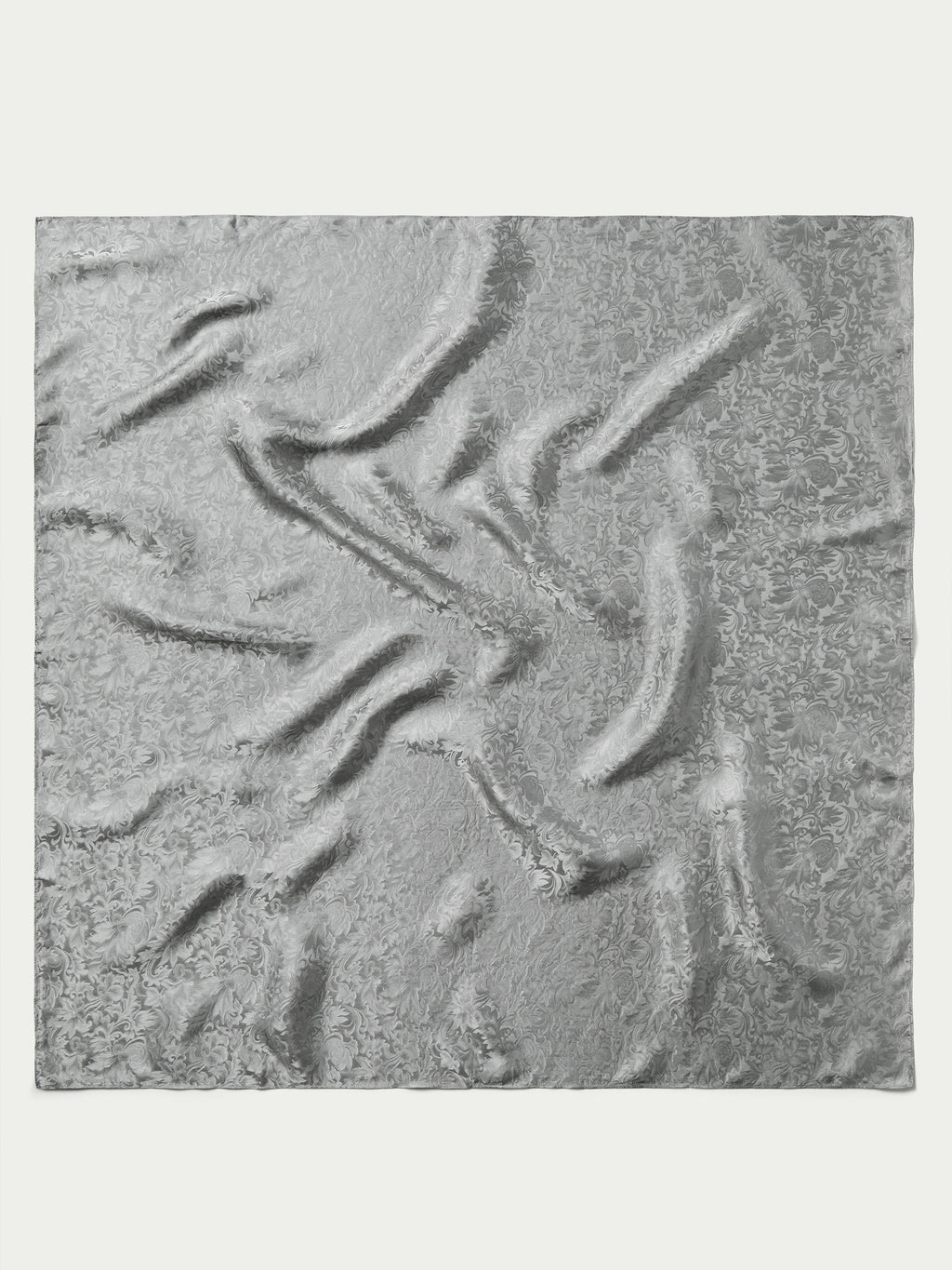 Silver jacquard wild rag fabric close-up with textured swirl pattern