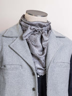 Silver jacquard wild rag scarf with draped neck tie, worn under a coat