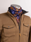 Paisley wild rag scarf in blue with orange and red border pattern, worn on neck