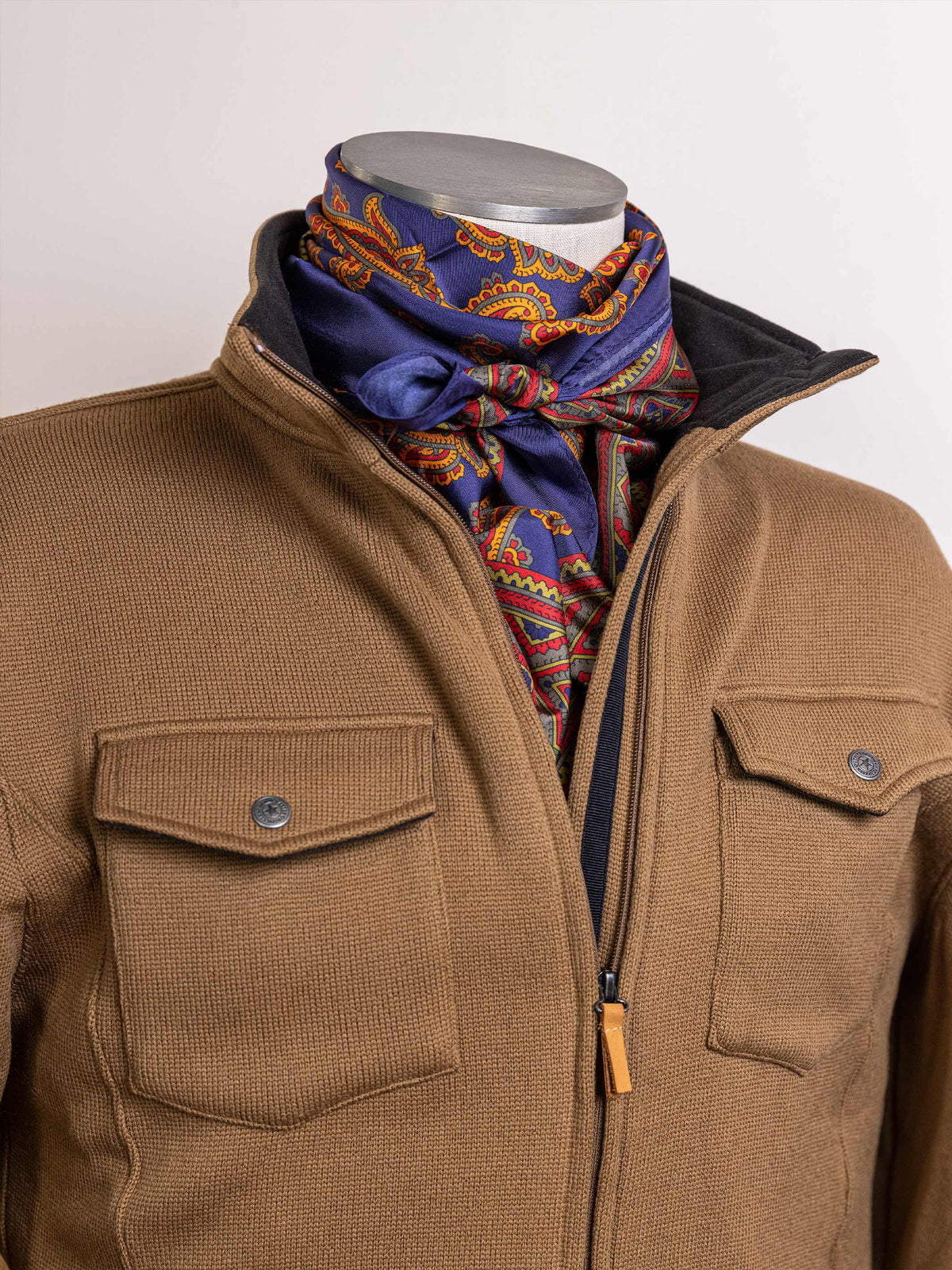 Paisley wild rag scarf in blue with orange and red border pattern, worn on neck