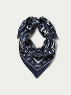 Navy wild rag bandana with white paisley pattern, folded into a triangle
