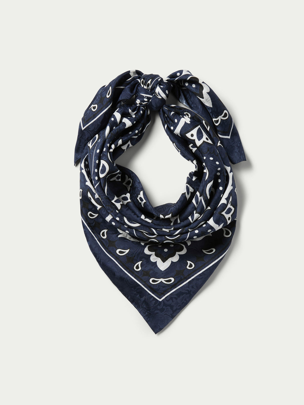 Navy wild rag bandana with white paisley pattern, folded into a triangle