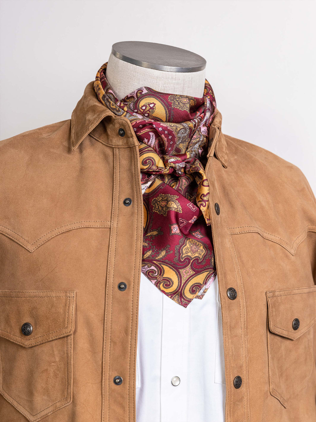 Paisley wild rag scarf in rust, red, and gold paisley print, worn at the neck