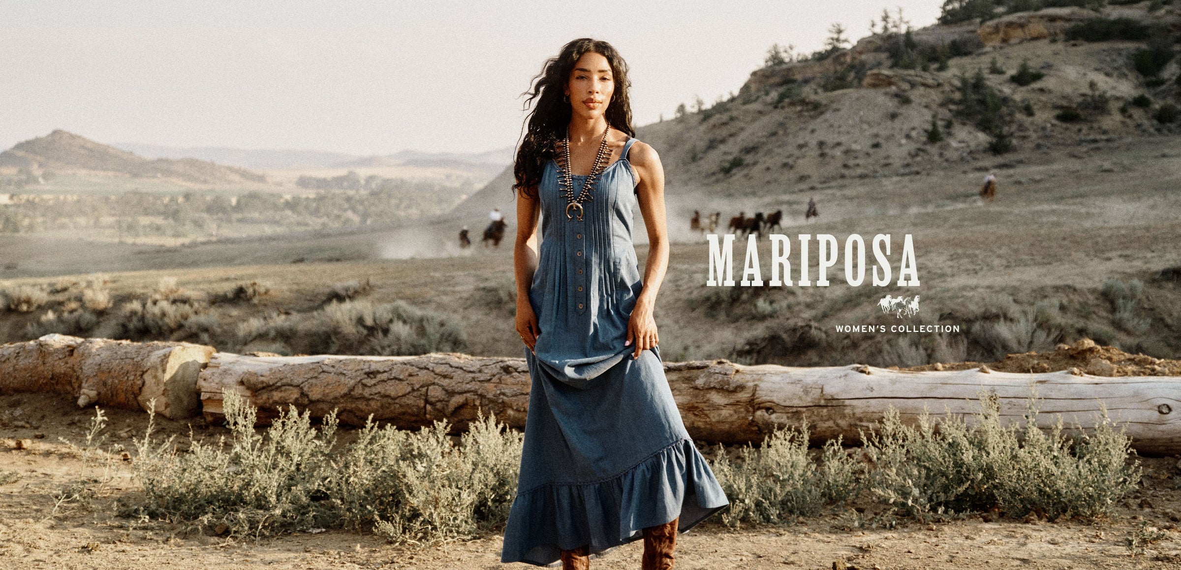 A woman stands outdoors in a dusty, mountainous landscape wearing a sleeveless denim maxi dress and brown boots. The brand name 'MARIPOSA' is displayed on the right side of the image.