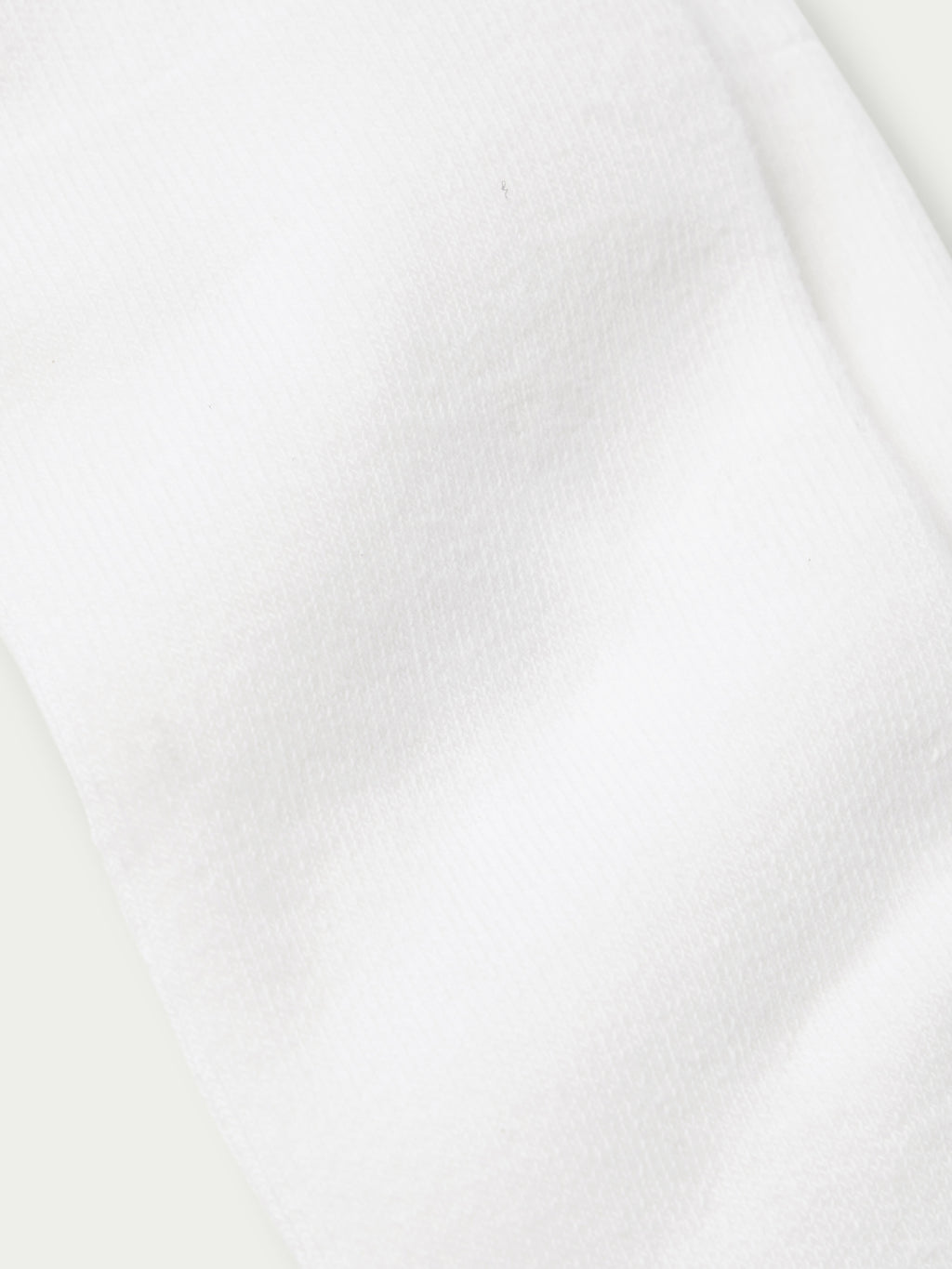White boot sock fabric close-up with smooth knit texture
